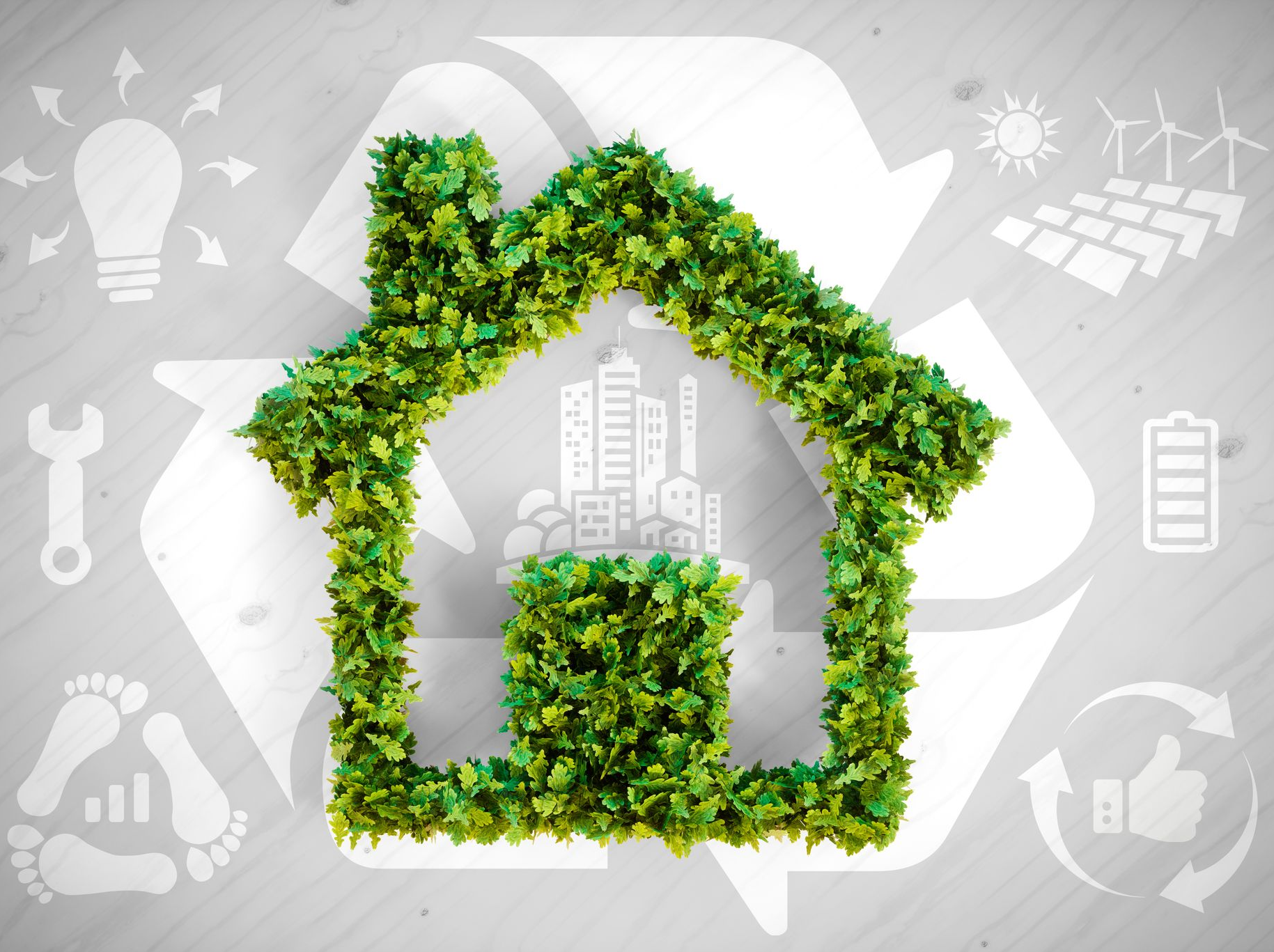 Une maison verte faite de feuilles à l'intérieur d'un symbole de recyclage.