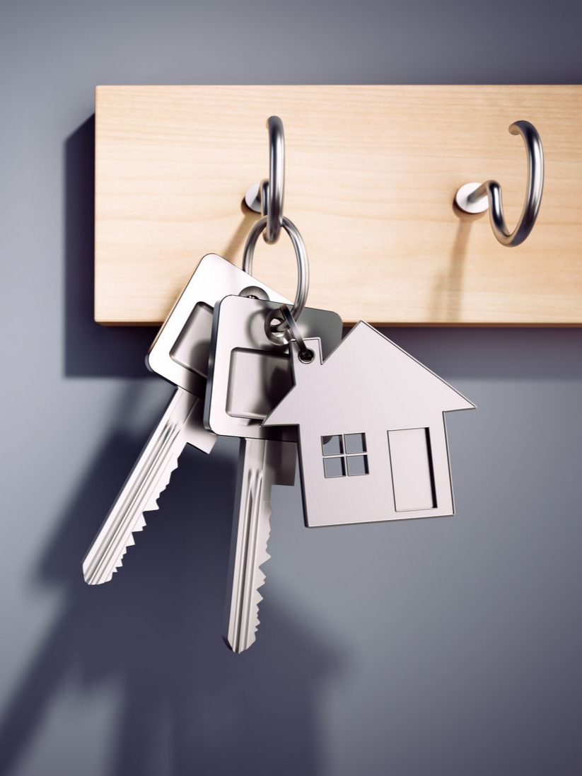 Des clés avec un porte-clés en forme de maison accroché à un crochet.