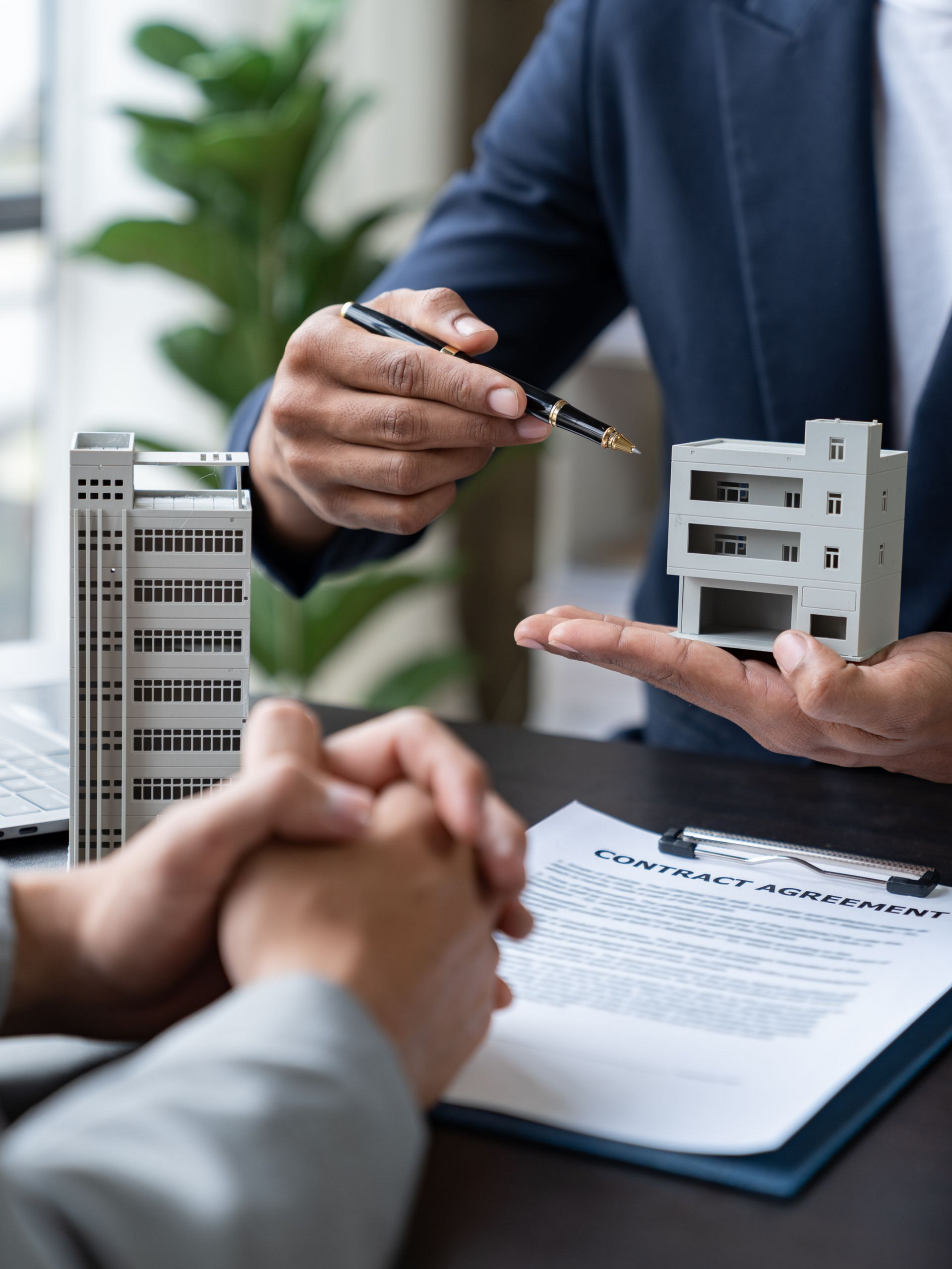 Une personne désigne du doigt une maquette de bâtiment.