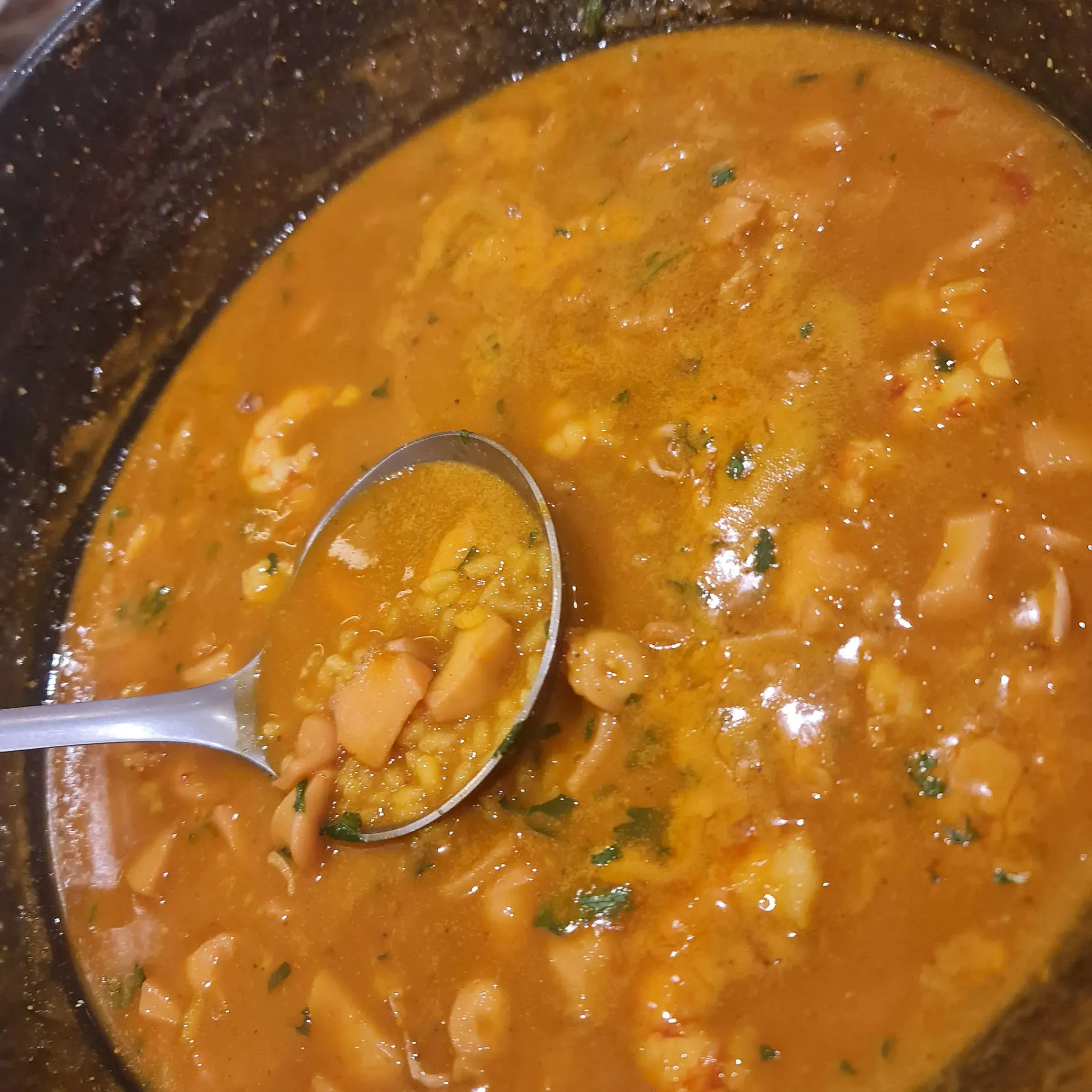 Un primer plano de una olla de sopa con una cuchara dentro.