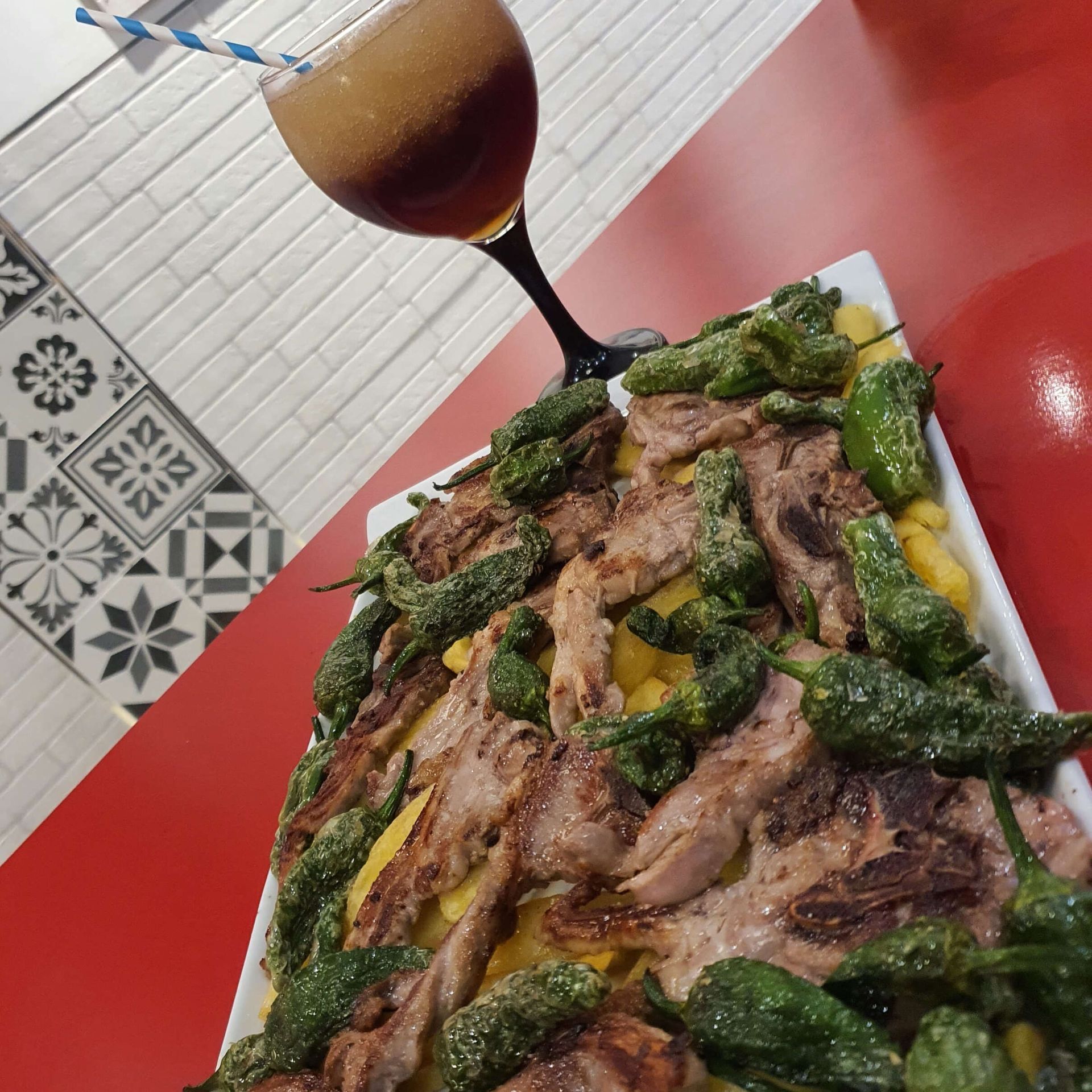 Un plato de comida y un vaso de cerveza en una mesa.