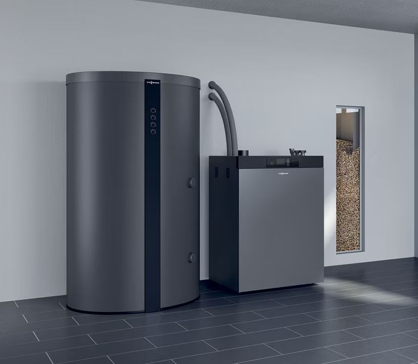 Une chaudière à granulés grise contre un mur.