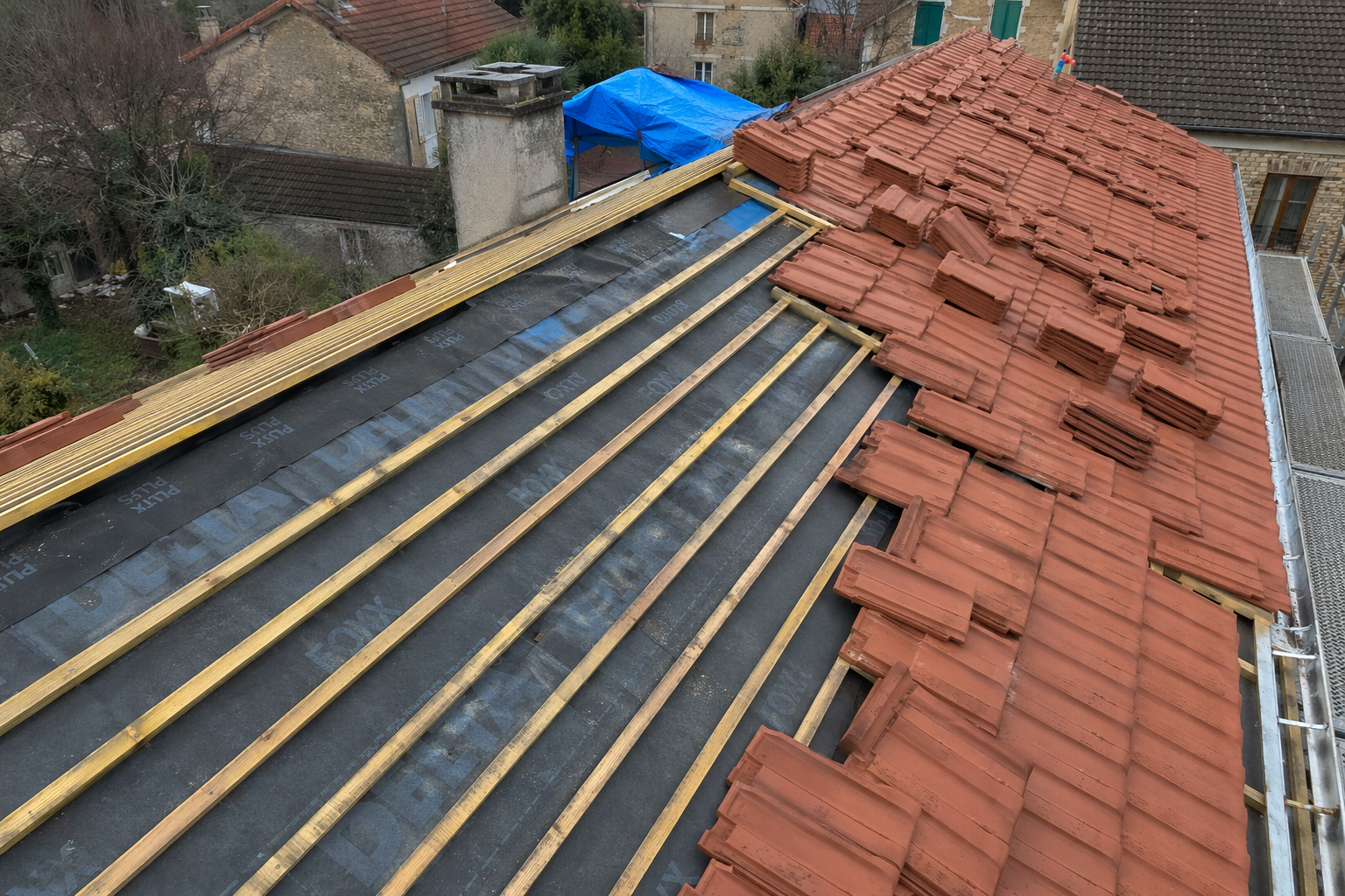 Vue en plongée d'un toit de tuiles en terre cuite orange vif.