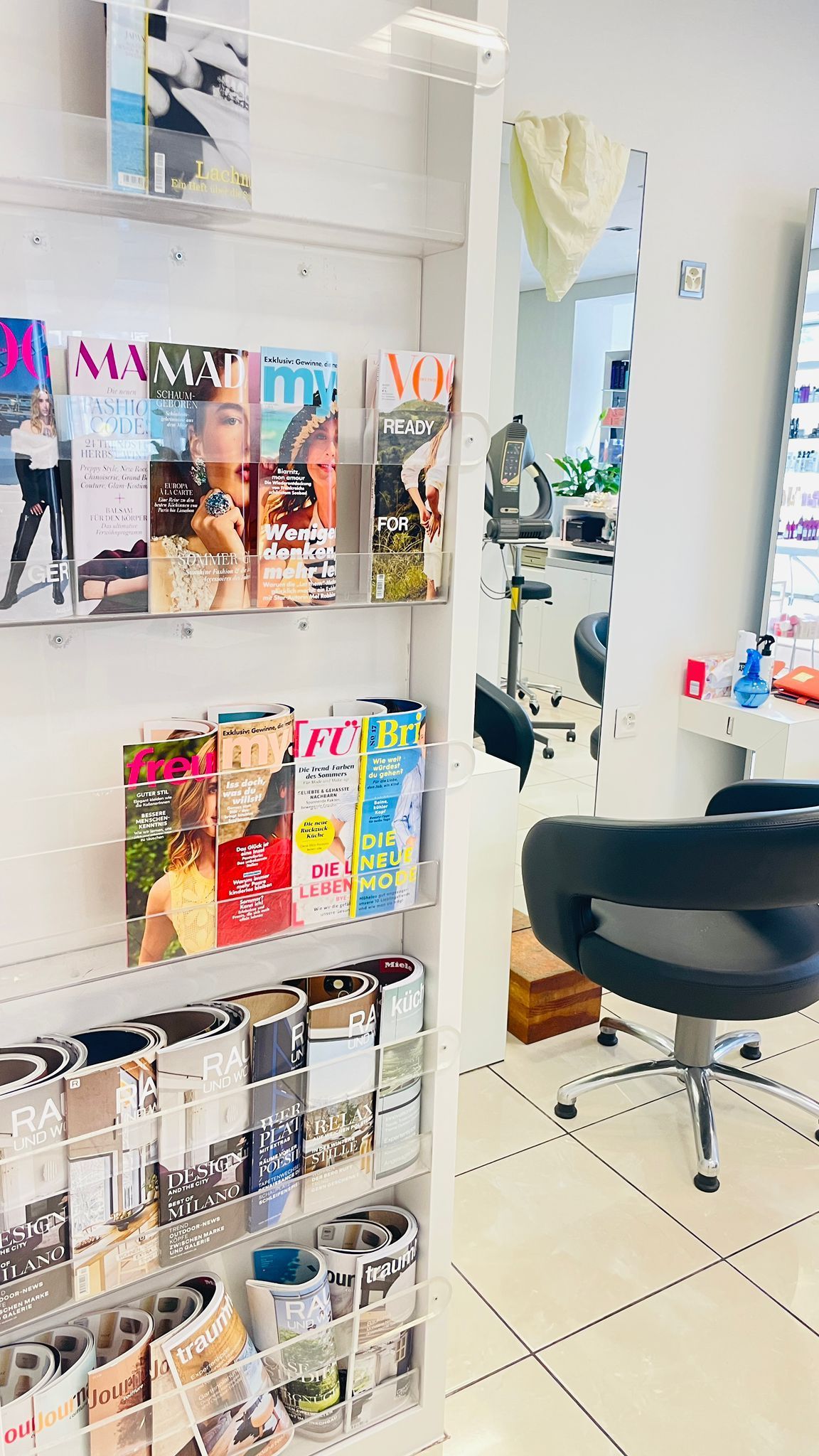 Inneneinrichtung eines Friseursalons mit ausgestellten Zeitschriften.