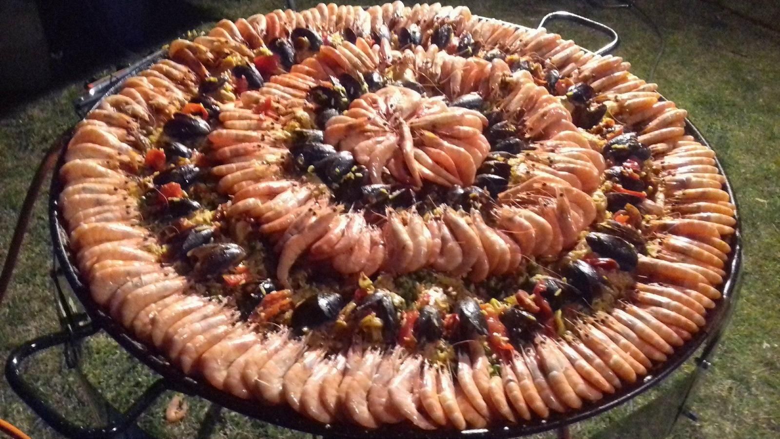 Plateau de paella avec beaucoup de crevettes.