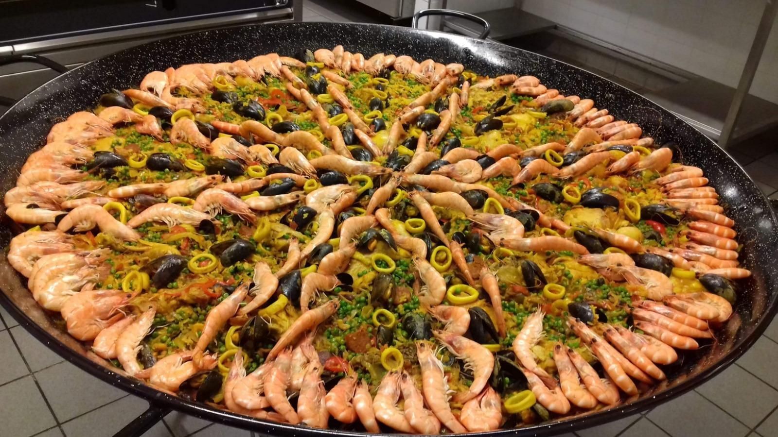 Plateau de paella avec crevettes décoratives.