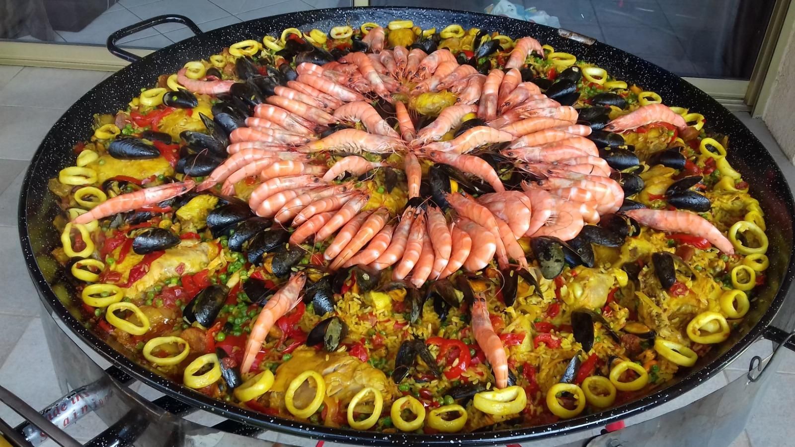 Plateau de paella avec fruits de mers et poulet.