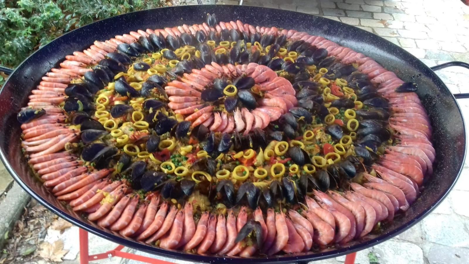 Plateau de paella avec calamar en décoration.