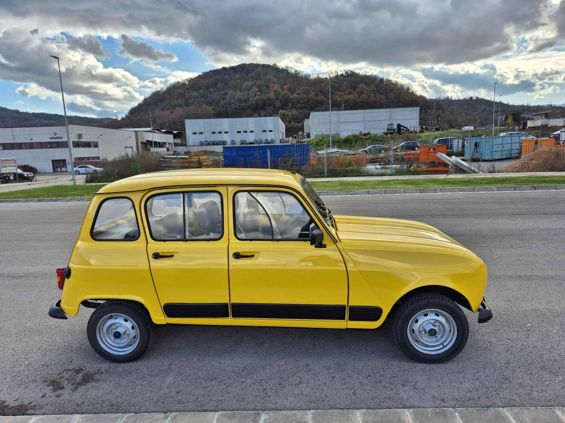 Un coche amarillo está aparcado al costado de la carretera.