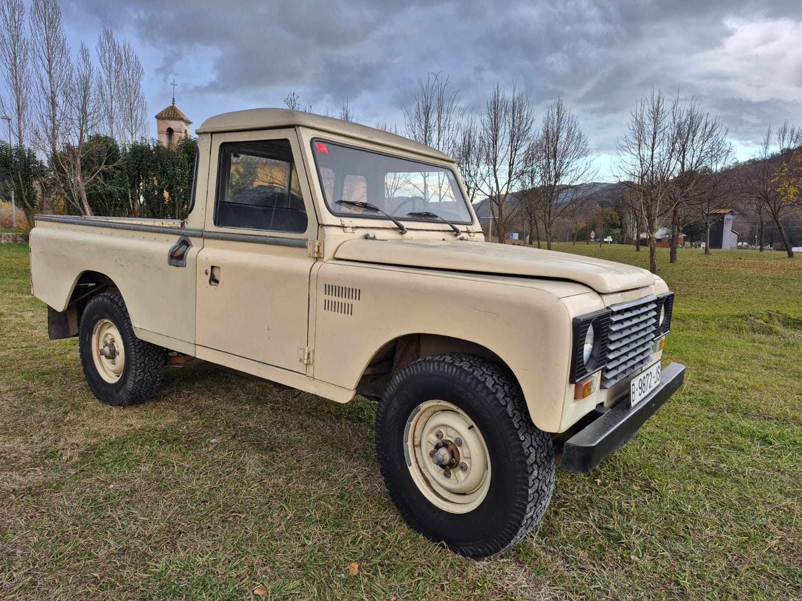 Una camioneta blanca está estacionada en un campo de hierba.