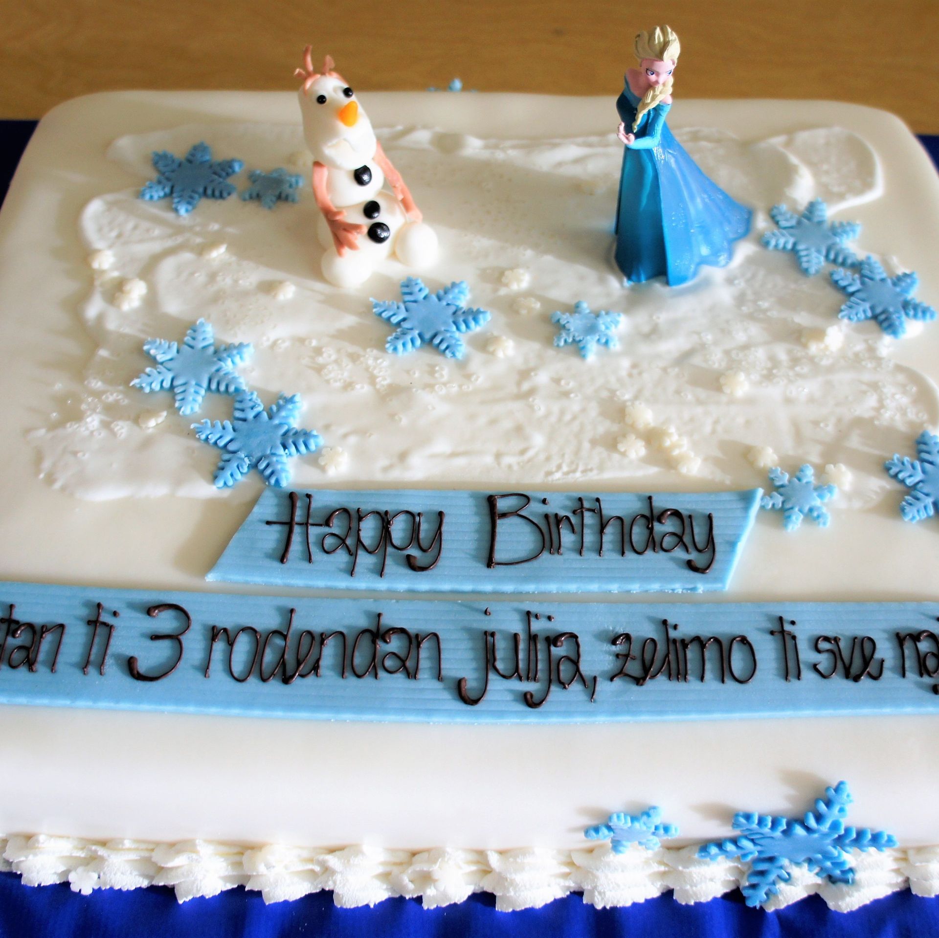 Eine Geburtstagstorte mit einem Schneemann und einer Prinzessin darauf