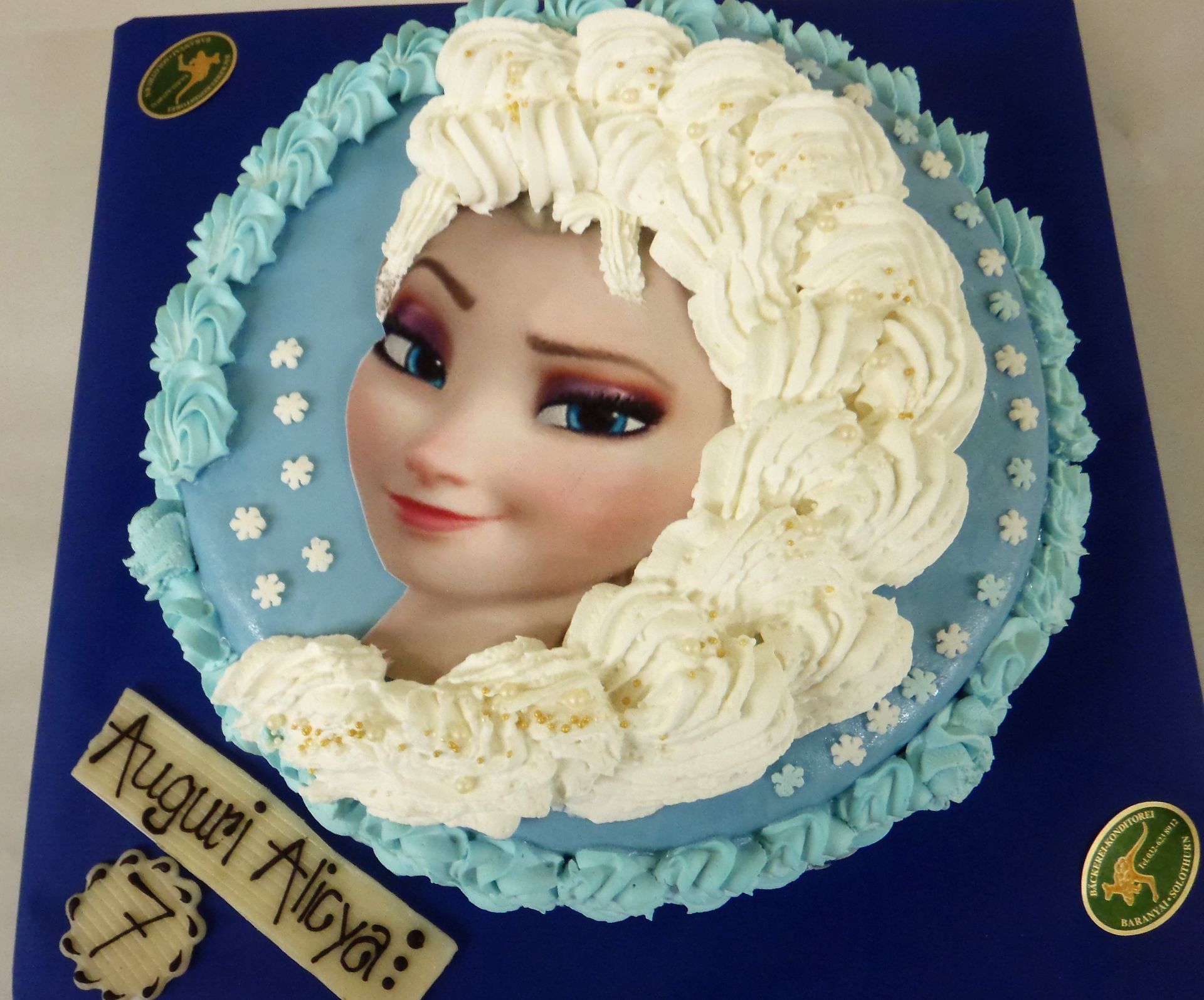 Eine Geburtstagstorte mit einem Bild von Elsa darauf