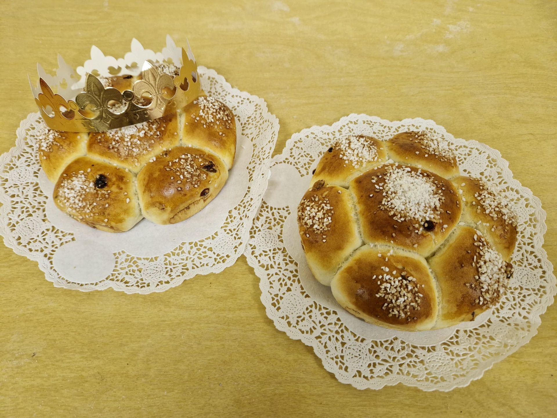 Zwei Brote auf einer Spitzenserviette auf einem Tisch
