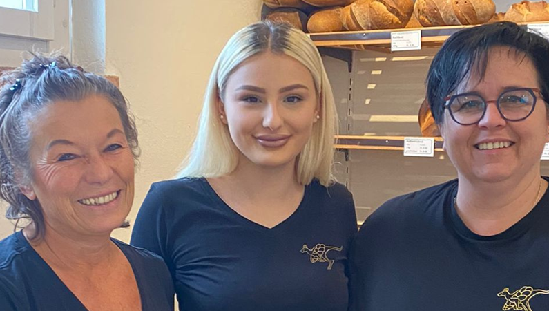 Drei Frauen posieren in einer Bäckerei für ein Foto.