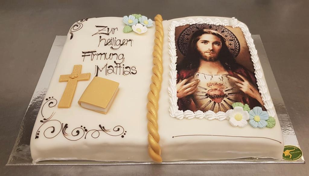 Ein Kuchen, der wie ein offenes Buch aussieht und auf dem sich ein Bild von Jesus befindet