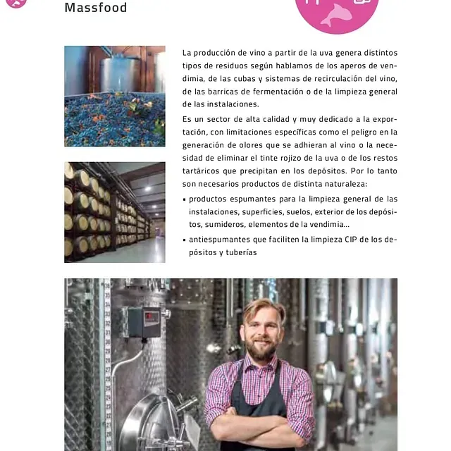 Un hombre con delantal está de pie en una fábrica con los brazos cruzados.