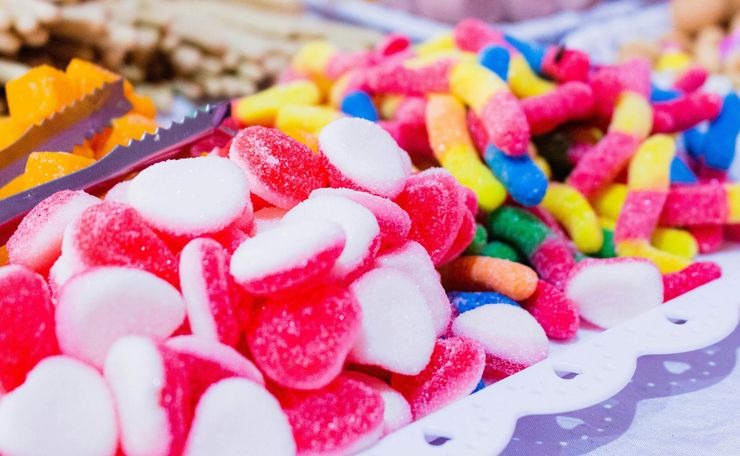 Surtido de caramelos de colores brillantes: rosa, amarillo, azul y blanco, en una bandeja de presentación.