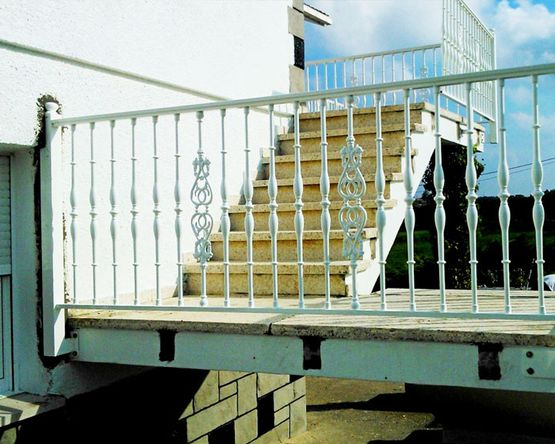 Una barandilla blanca con escaleras al fondo.