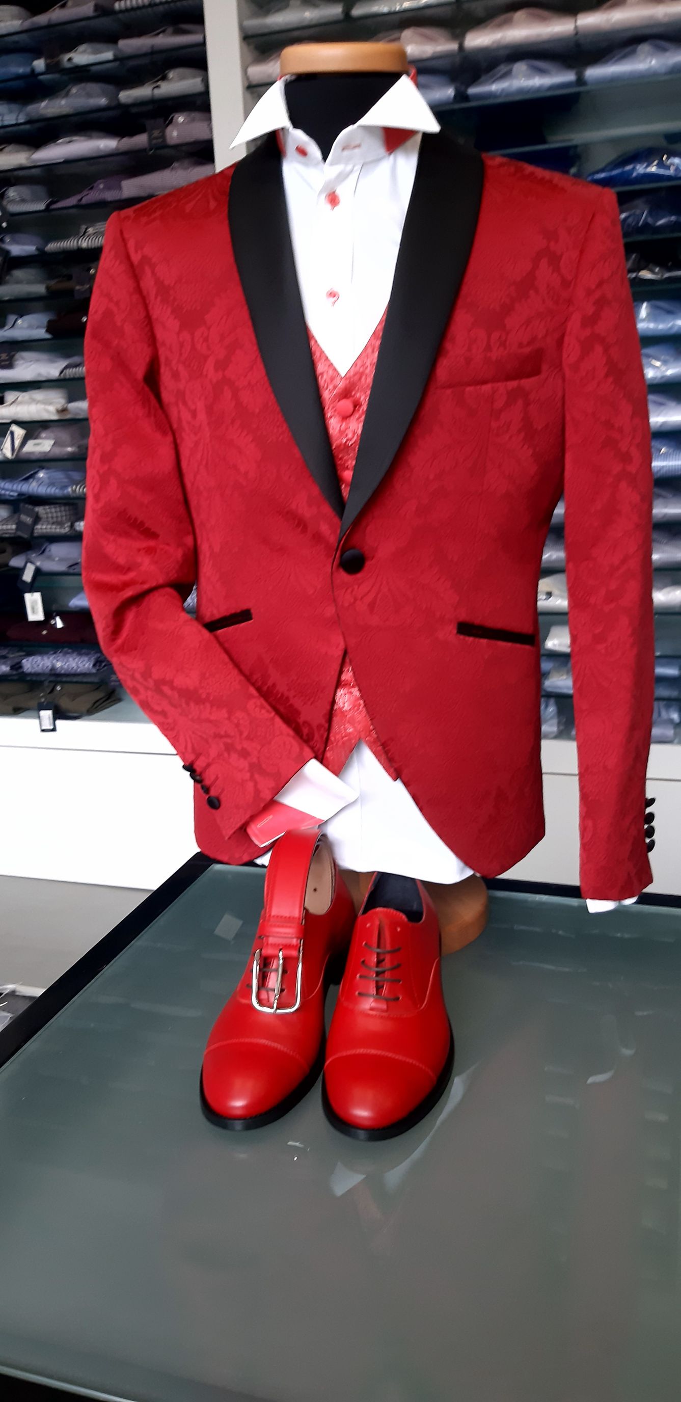 Un manichino che indossa uno smoking rosso e scarpe rosse