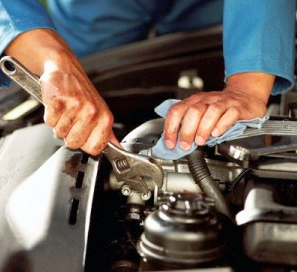 Uma pessoa está trabalhando em um motor de carro com uma chave inglesa