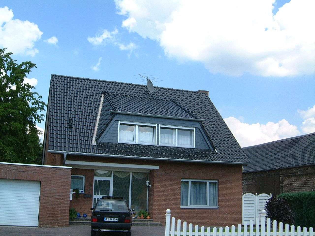 erneuertes dunkles Dach eines roten Hauses