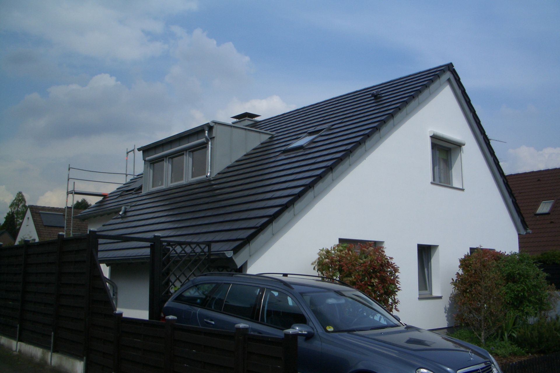 weißes Wohnhaus mit dunklem Spitzdach