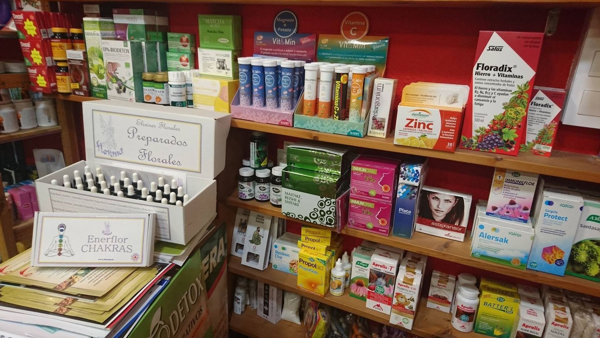 Estantes de suplementos y vitaminas en una tienda, con una caja blanca de viales en primer plano.