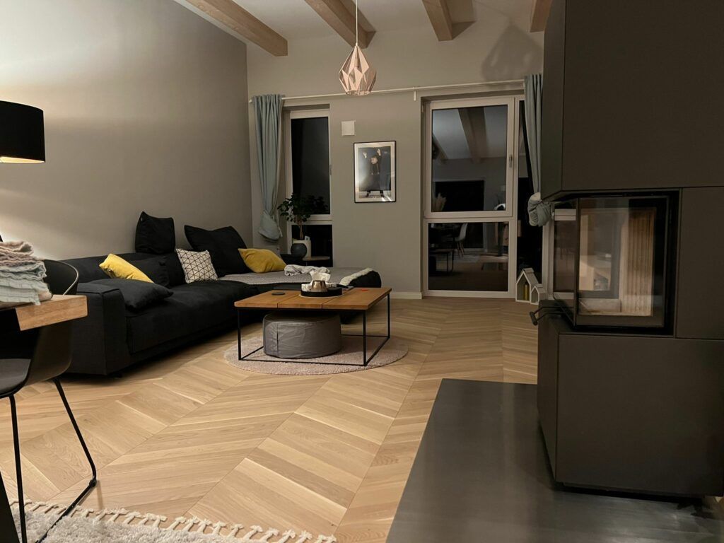 Ein Wohnzimmer mit Sofa, Couchtisch und Kamin.