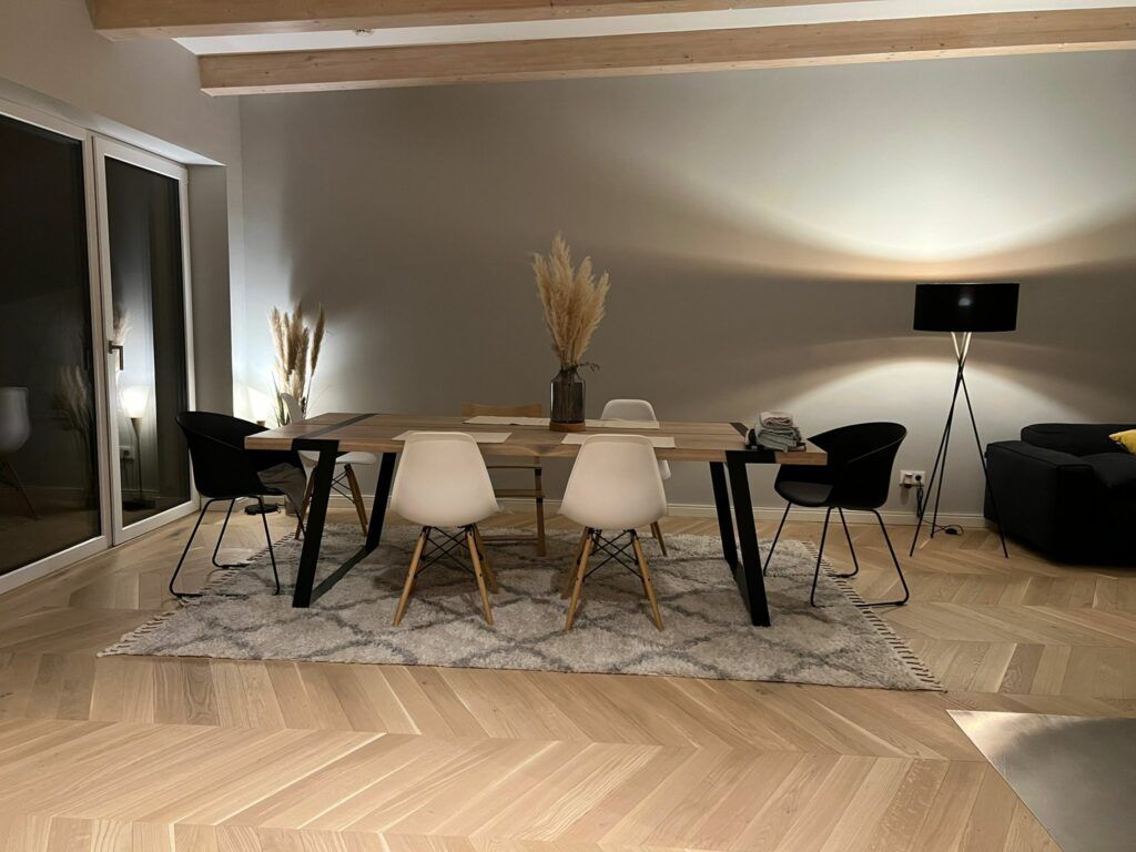 Ein Esszimmer mit Tisch, Stühlen und einem Teppich.