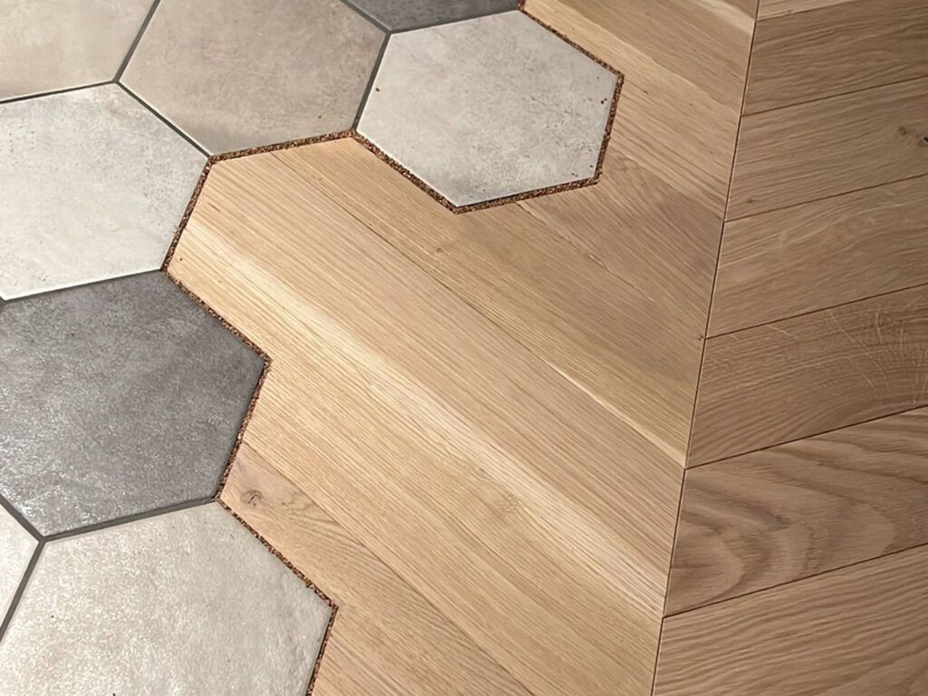 Eine Nahaufnahme eines Holzbodens mit sechseckigen Fliesen.