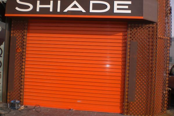 Un escaparate con una persiana naranja y un cartel que dice shiade