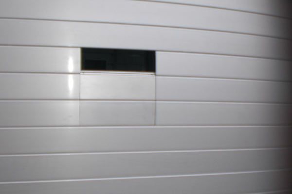 Una pared blanca con un cuadrado negro en el medio.