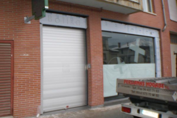 Un camión blanco está estacionado frente a un edificio de ladrillos.
