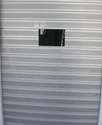 Una puerta de garaje de metal con una pequeña ventana.