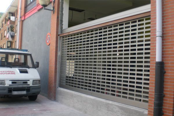 Una camioneta blanca está estacionada frente a un edificio de ladrillos.