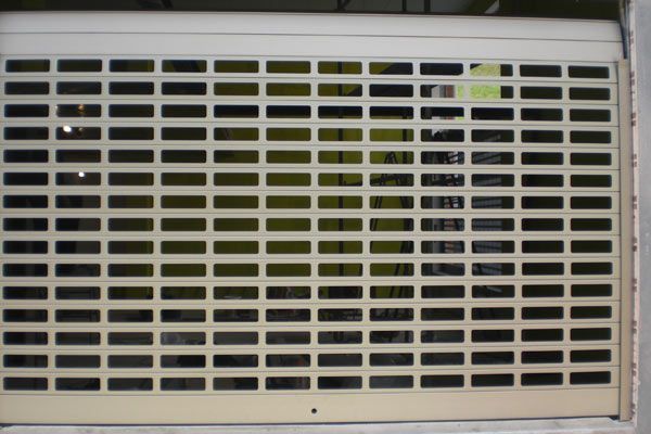 Una puerta de garaje blanca con muchos agujeros.