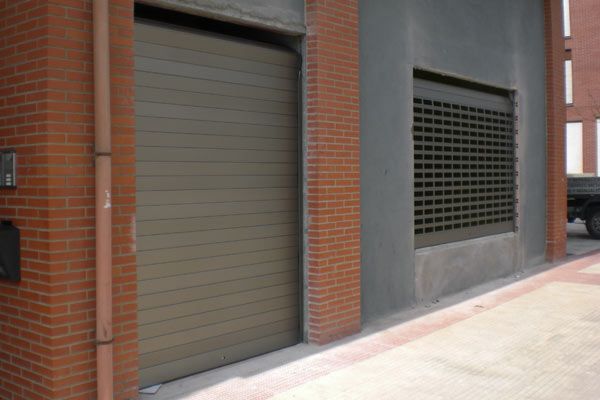 Un edificio de ladrillo con puerta de garaje y buzón.