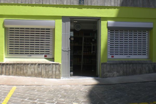 Un edificio verde con persianas blancas en las ventanas.