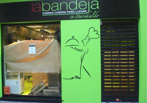 Un edificio verde con un cartel que dice la bandeja.
