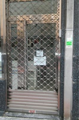 Una puerta de acero inoxidable con un cartel que dice que está cerrada.