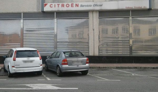 Dos coches están aparcados delante de una tienda Citroën.