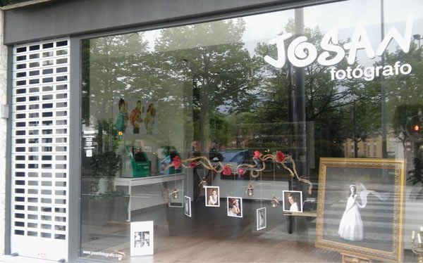 Un escaparate con un cartel que dice 'Josa Fotógrafo'.