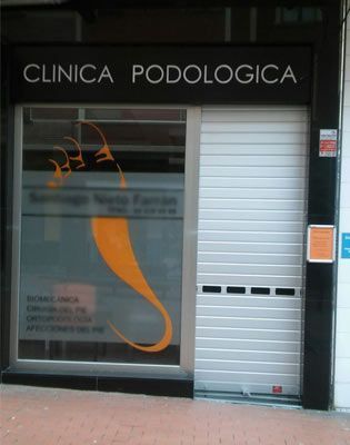 Un escaparate con un cartel que dice clínica podológica.