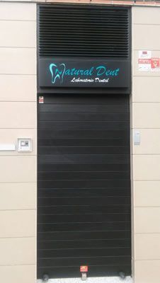 Una puerta negra con un cartel encima que dice abolladura natural