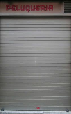 Un escaparate con un cartel que dice peluquería.