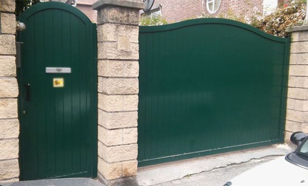 Un coche blanco está aparcado delante de una puerta verde.