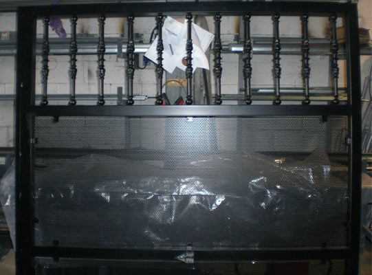 Una valla de metal negra con una tela blanca colgando de ella.