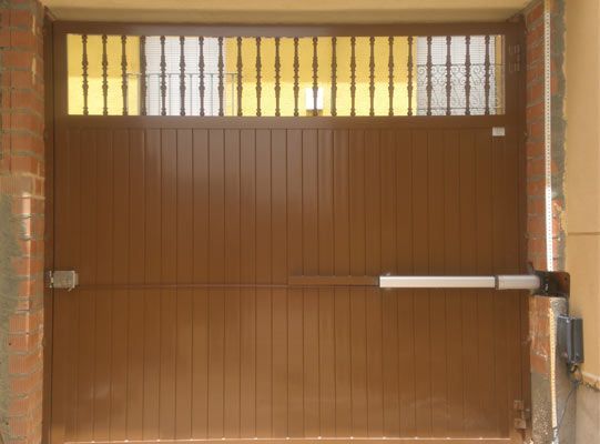 Una puerta de garaje marrón con una ventana amarilla.