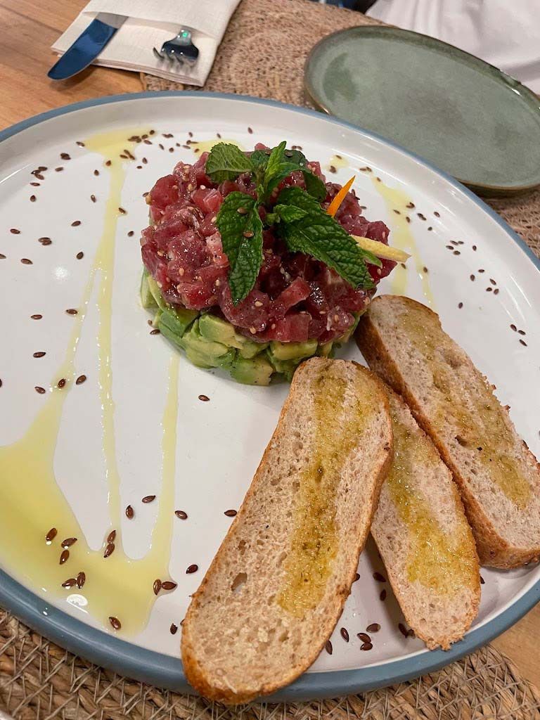 Un plato de comida con pan y aguacate sobre una mesa.