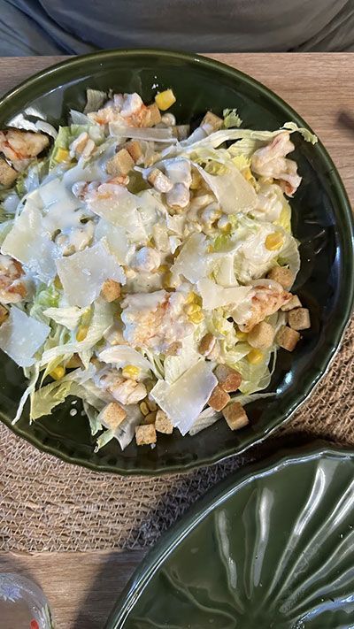 Un primer plano de una ensalada en un plato sobre una mesa.